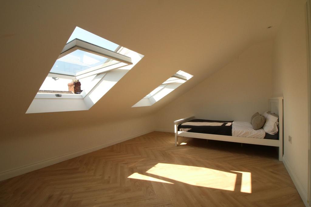 Bright attic bedroom with angled skylight windo...