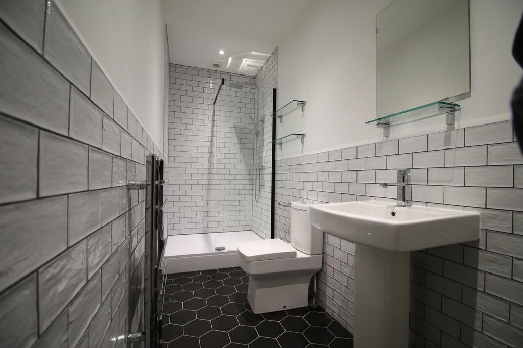 Modern tiled bathroom with a walk-in shower, pe...