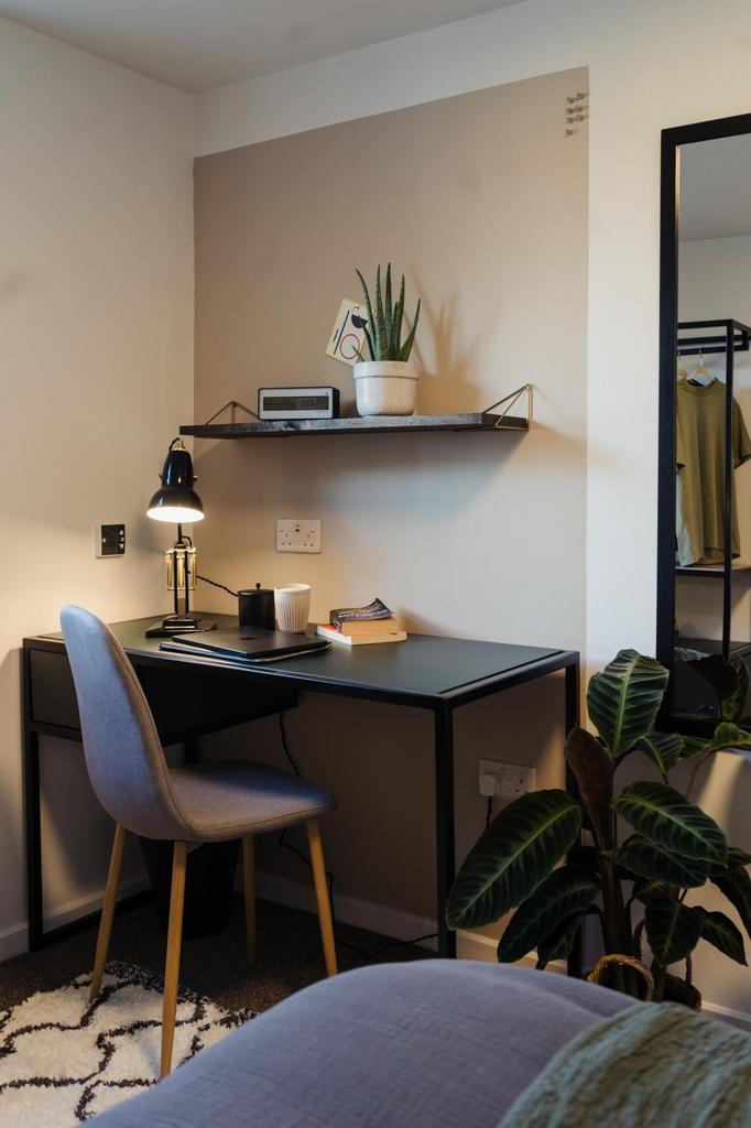 A cozy study area featuring a sleek desk with a...