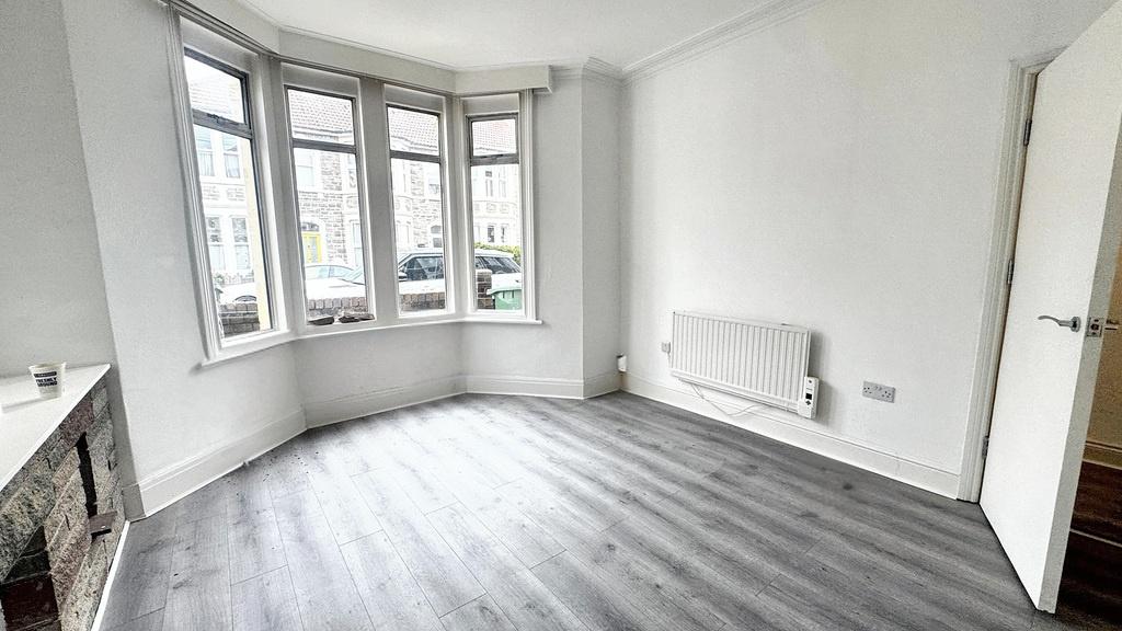 Bright living room with large bay window, conte...