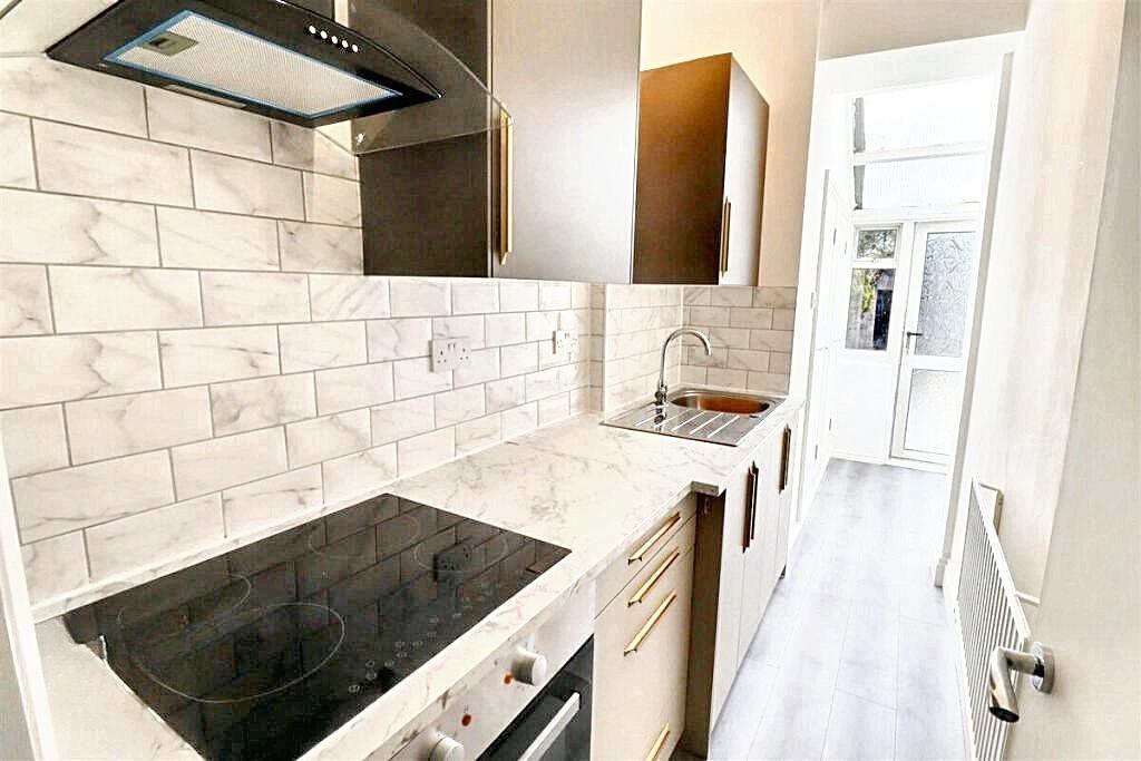 Bright, modern galley kitchen with white tiled ...