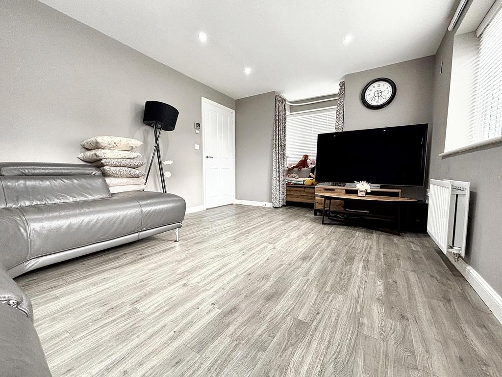 Bright, modern living room with light wood-effe...