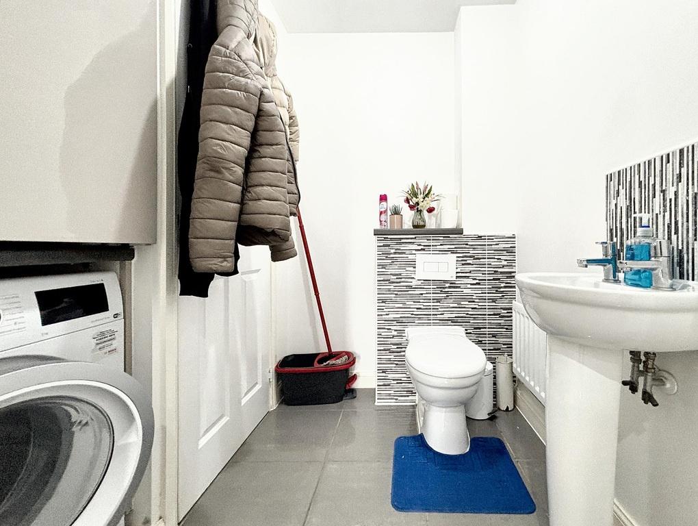Bright, modern bathroom with a white pedestal s...