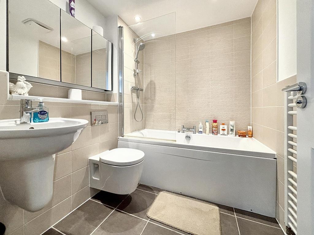 Modern bathroom with a bathtub and overhead sho...