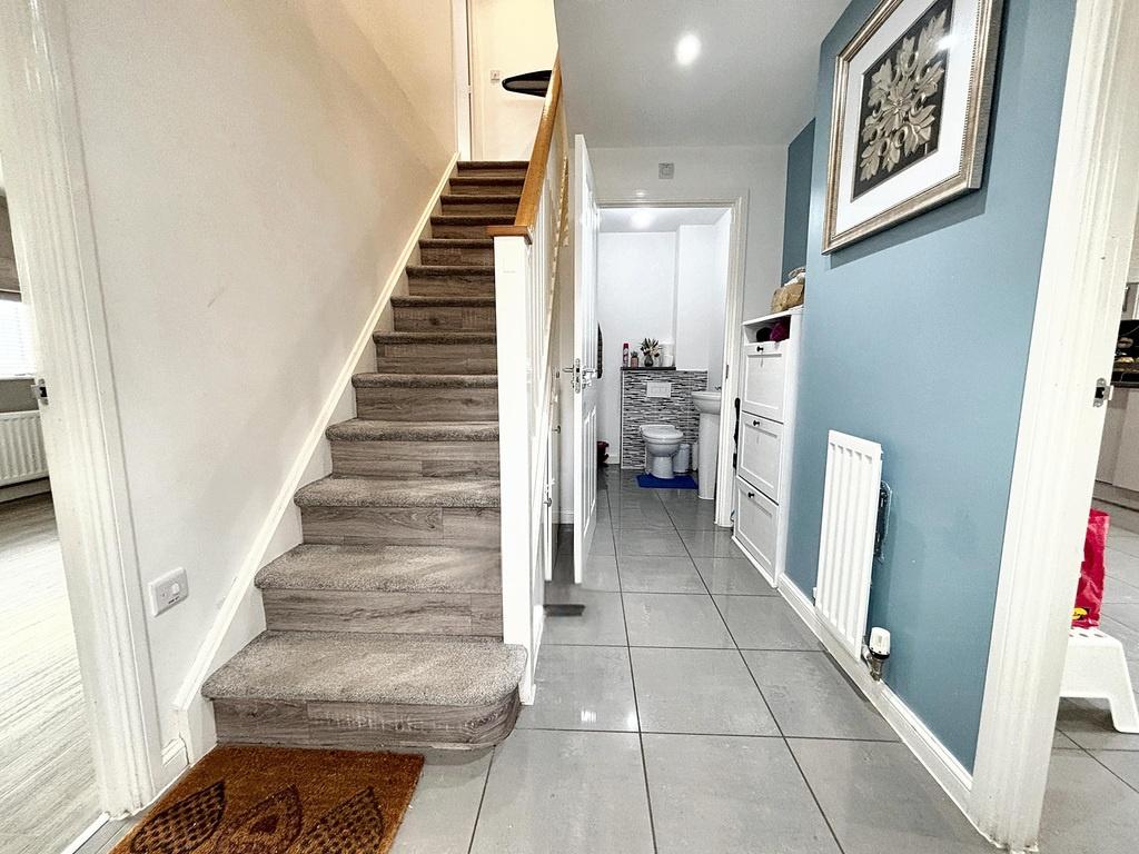 Bright, modern hallway with tiled flooring, car...