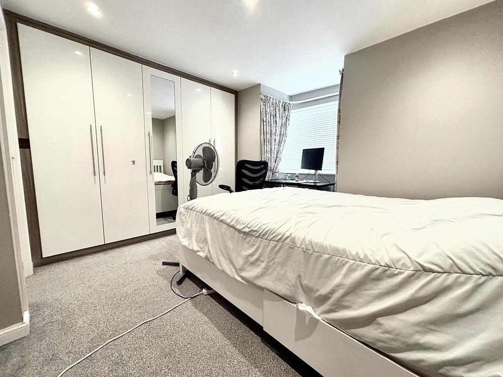 Bright, modern bedroom with built-in wardrobes,...