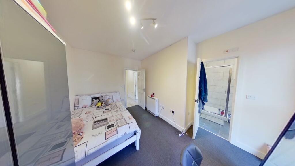 Bright, tidy bedroom featuring a double bed, bu...