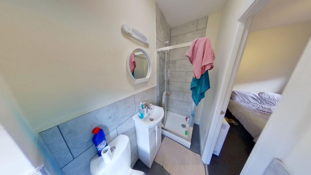 Compact modern bathroom with tiled shower cubic...
