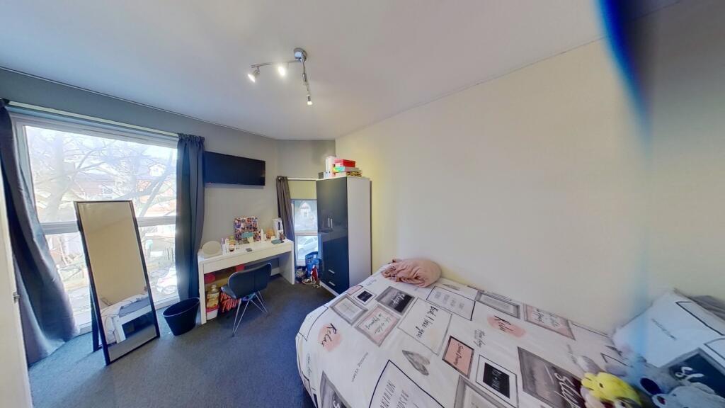 Bright single bedroom with a large window letti...
