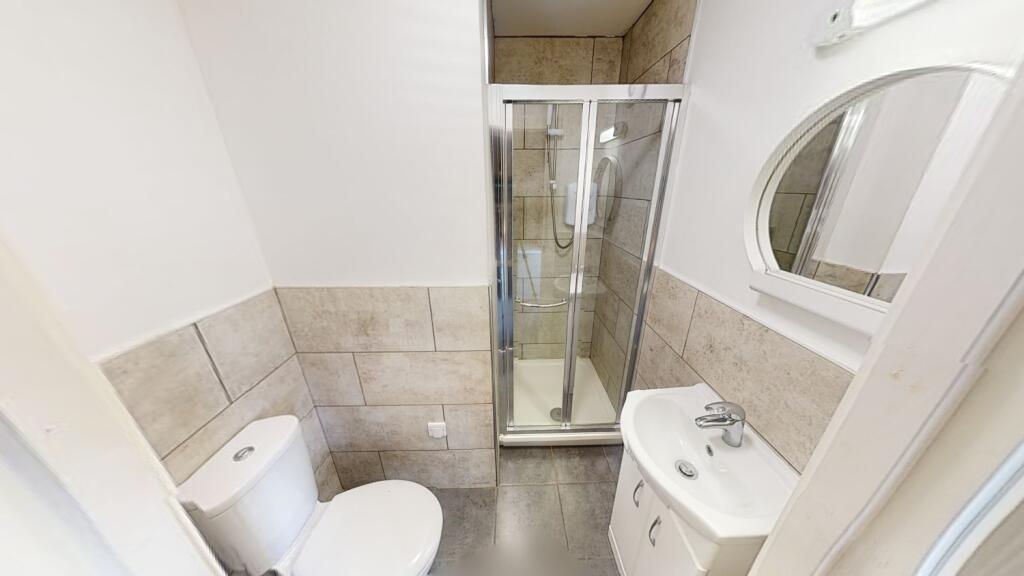 Well-presented bathroom featuring a corner show...