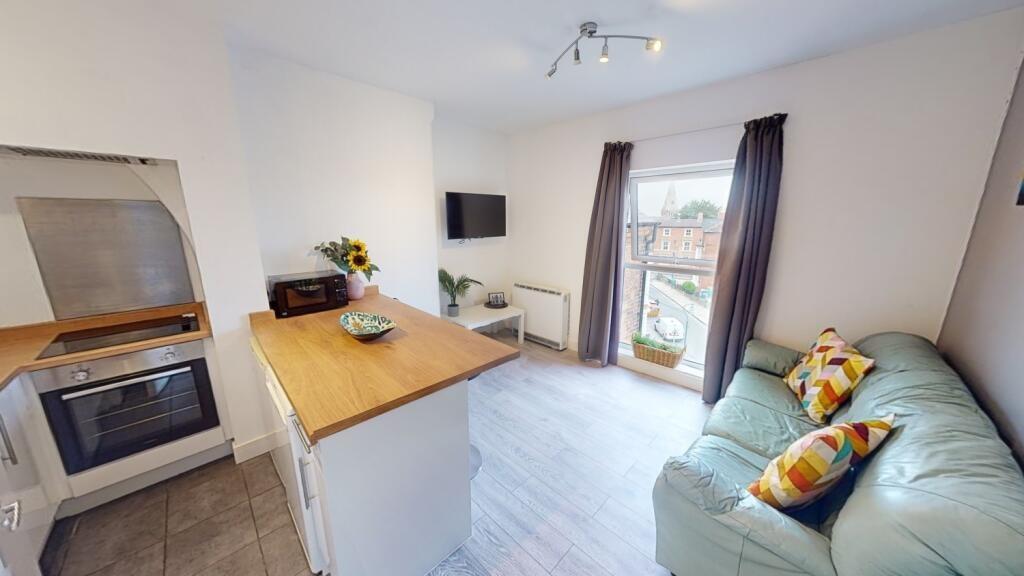 Bright open-plan living area with a comfy sofa,...