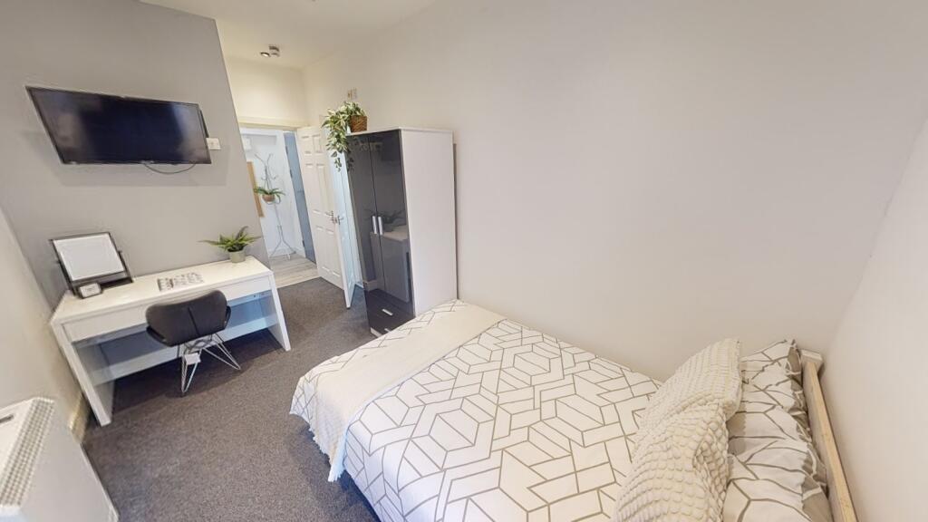 Bright, neatly arranged double bedroom with a c...
