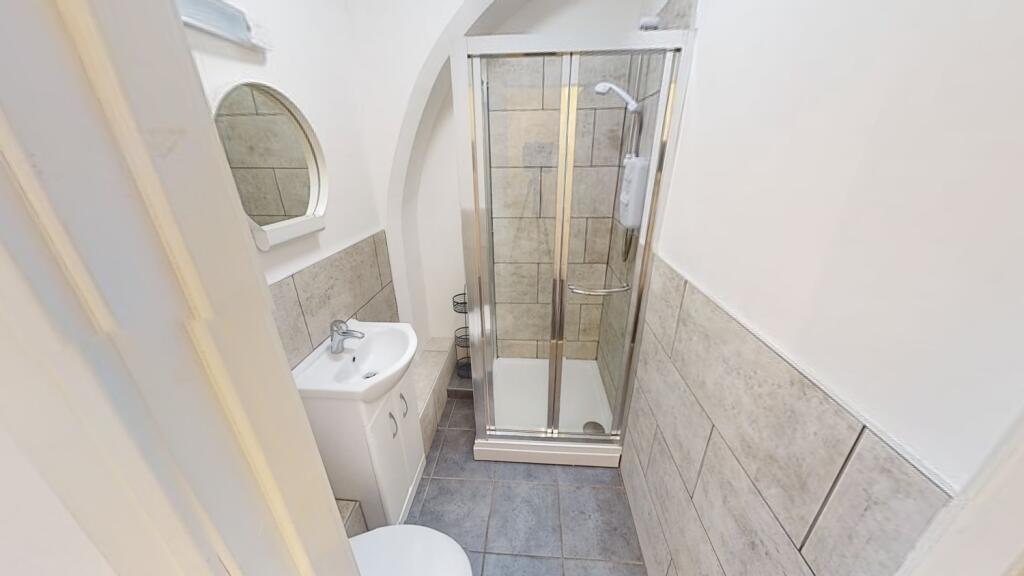 Bright, modern bathroom with a glass shower enc...