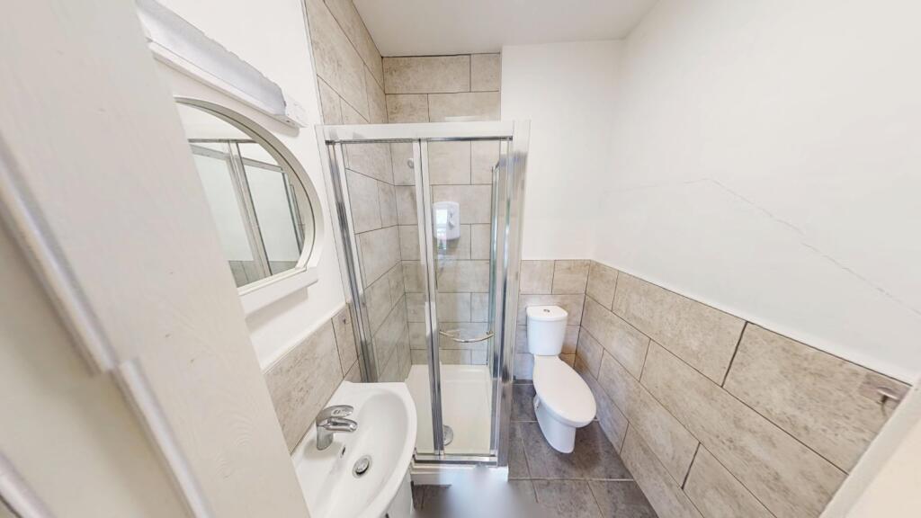 Bright, modern bathroom with a corner glass sho...
