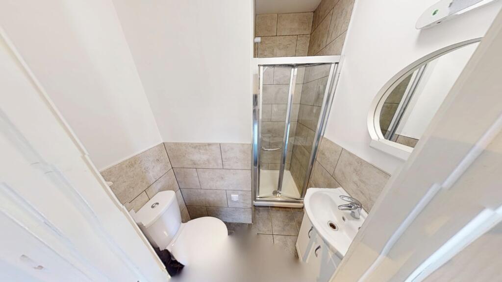 Bright, modern bathroom with an enclosed corner...