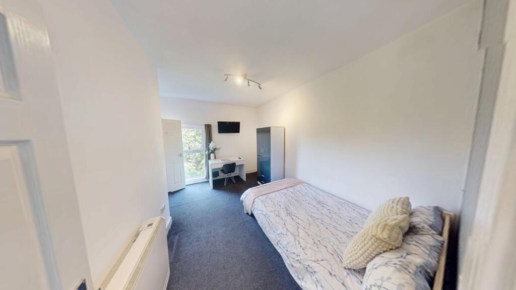 Bright, simply furnished single bedroom with a ...