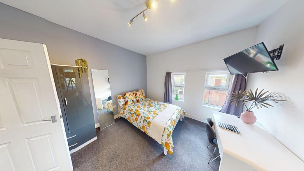 Bright, neatly presented bedroom with a pattern...