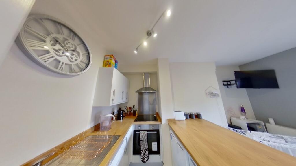 Contemporary galley kitchen with wood-effect wo...