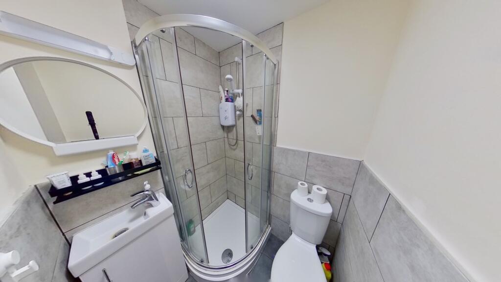 Modern bathroom with a curved glass corner show...