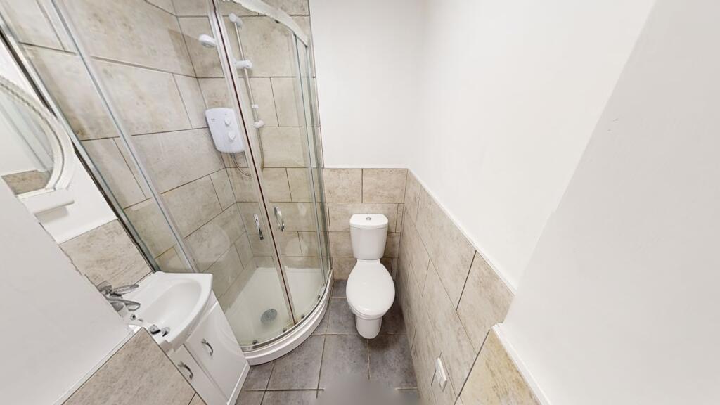 Modern bathroom with a curved glass shower encl...