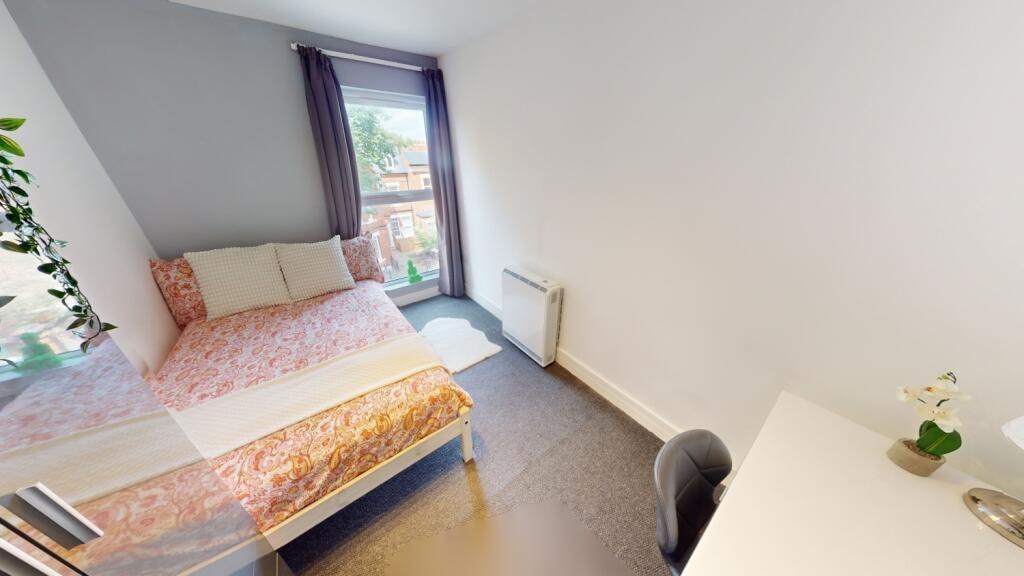 Bright, tidy bedroom with a bed beside a large ...