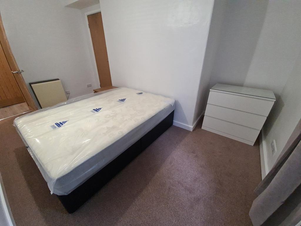 A well-maintained double bedroom with a comfort...