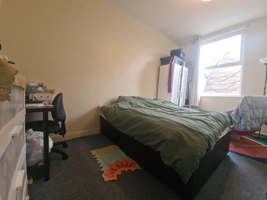 A modest bedroom featuring a bed and a window t...