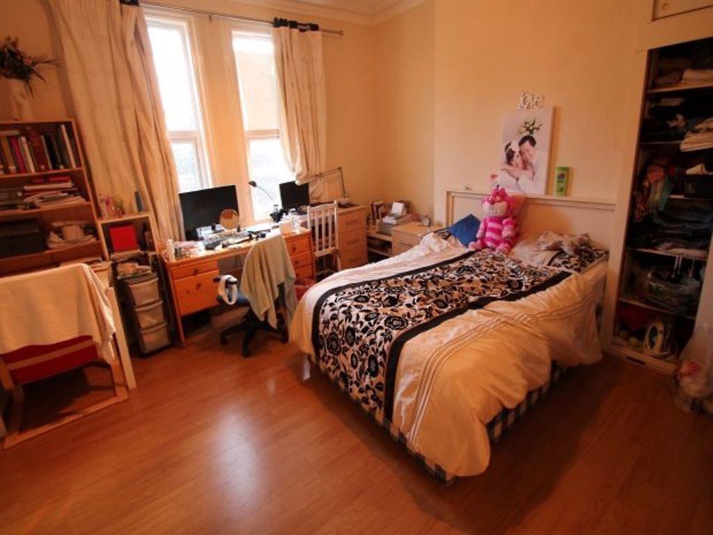 A cozy student bedroom with a single bed, a win...