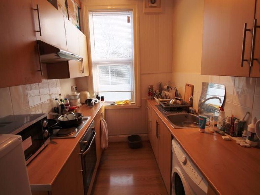 A compact kitchen with natural light from a win...