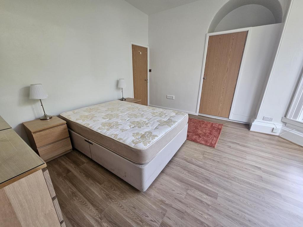 A bright and spacious master bedroom with a lar...