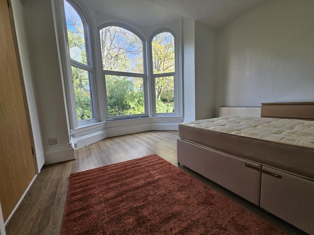 Bright and spacious master bedroom with large w...