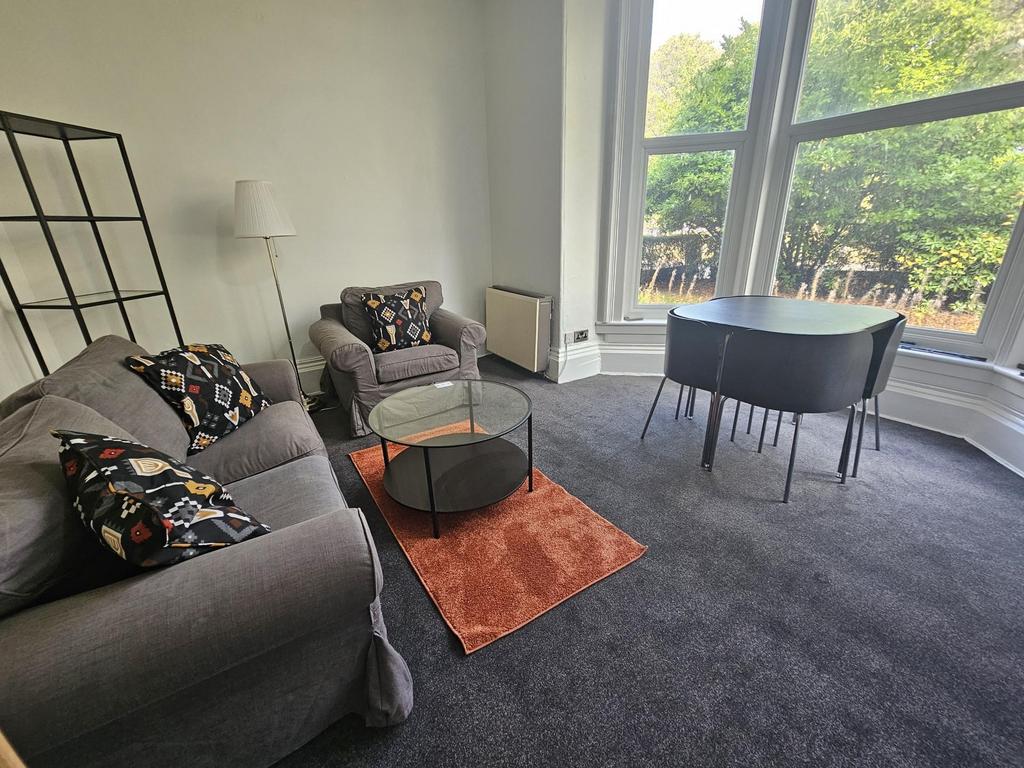 A bright and spacious living room with large wi...