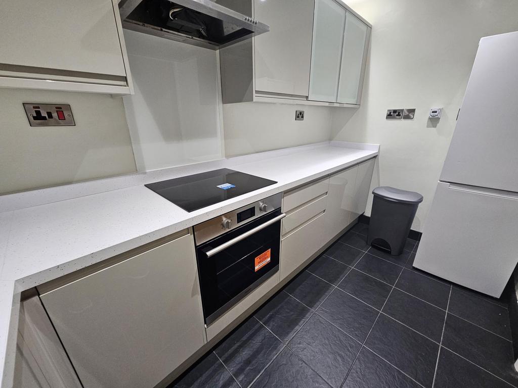 Modern fitted kitchen with sleek white worktops...