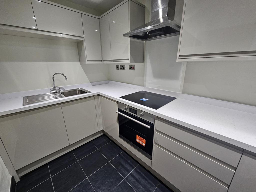 A modern and tidy kitchen with sleek white cabi...