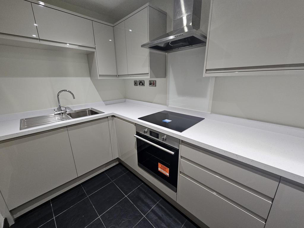 Modern, well-maintained kitchen with sleek whit...