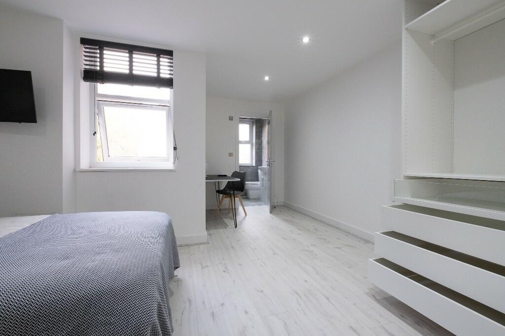 A spacious and bright bedroom with a comfortabl...