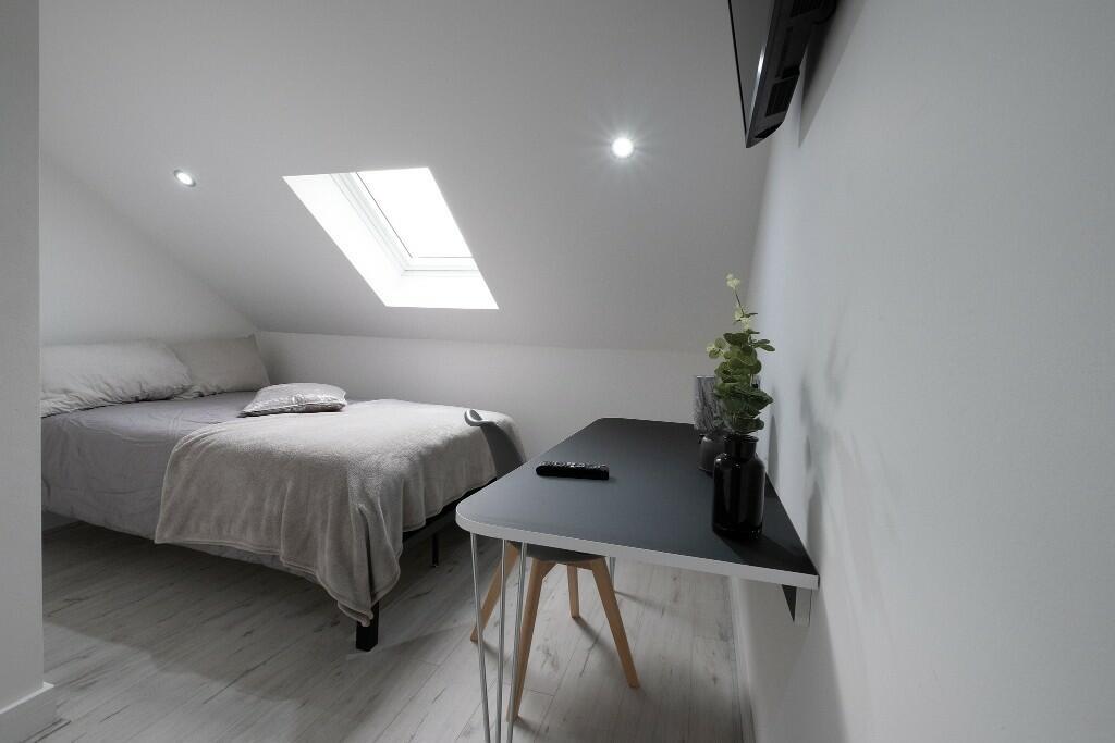 A bright and inviting bedroom featuring a large...