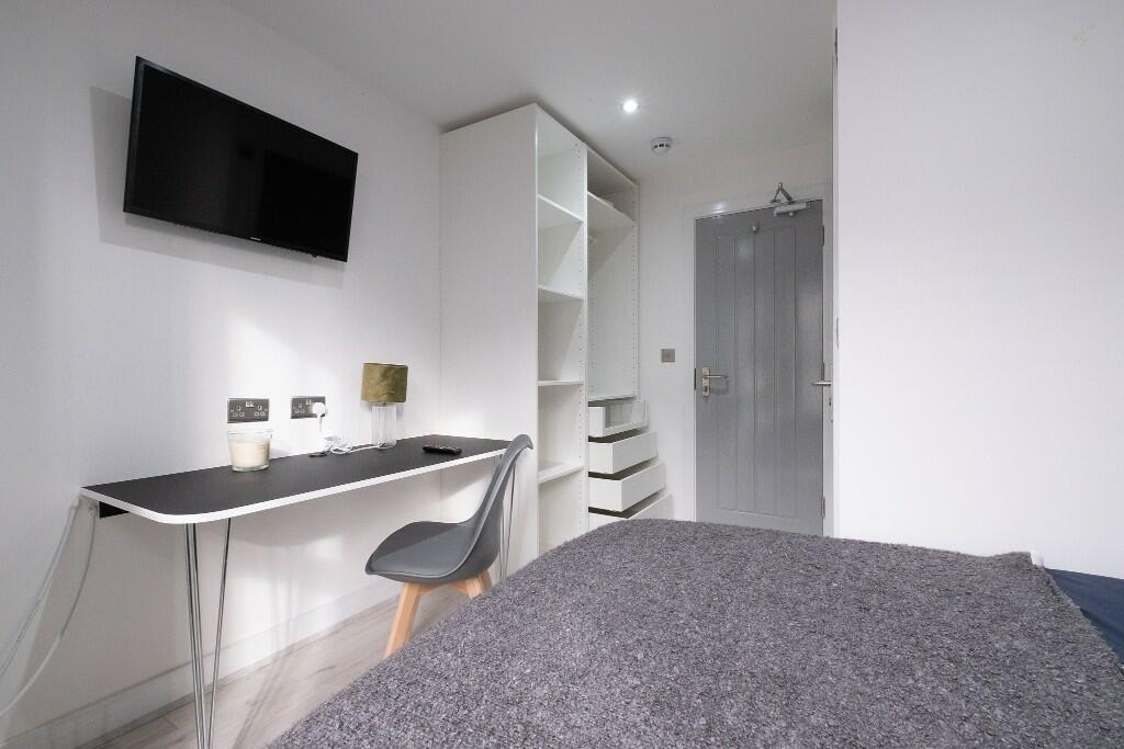 A modern bedroom featuring a comfortable bed, a...