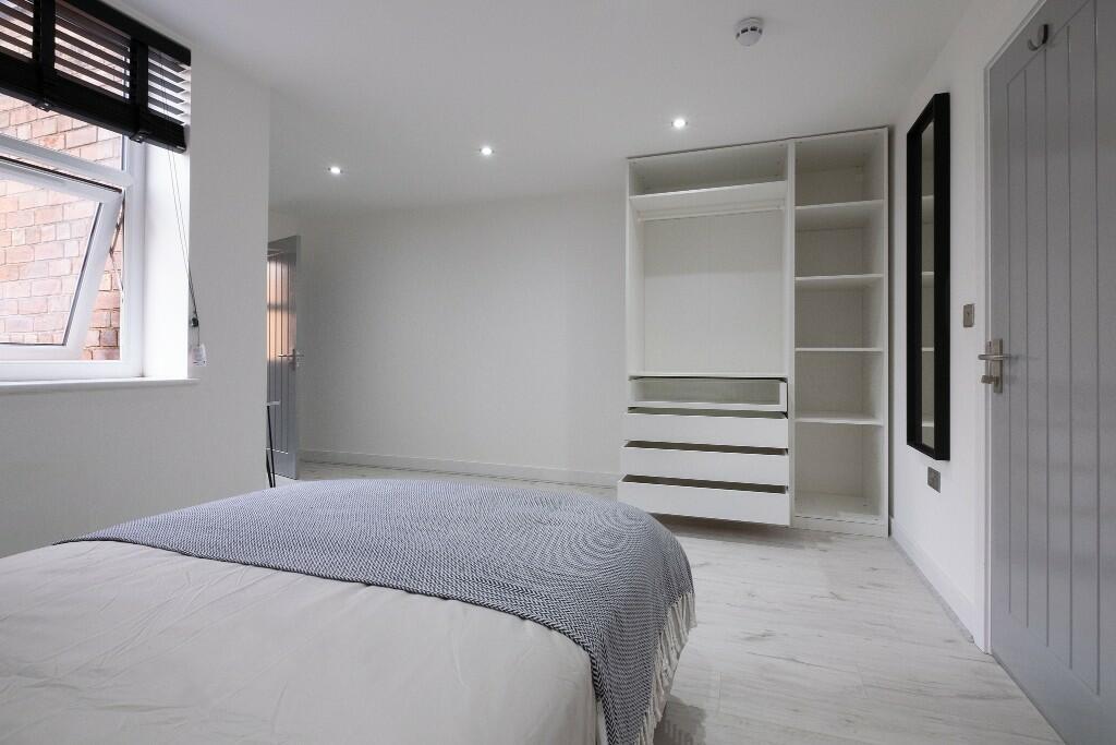 A clean, modern bedroom featuring a comfortable...