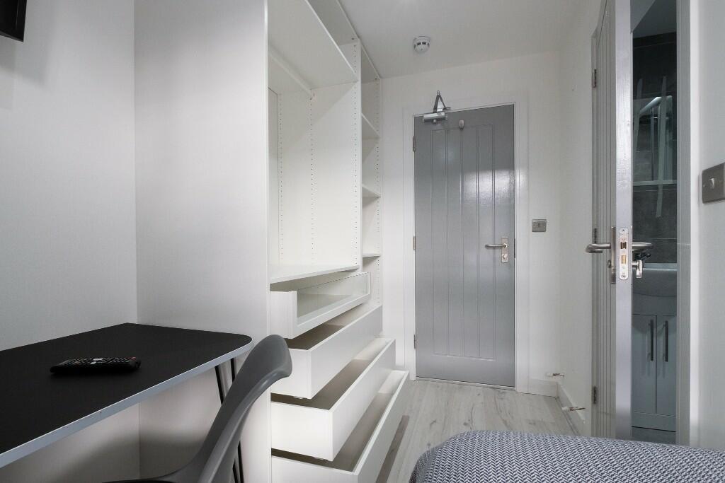 Neat, modern single bedroom with built-in shelv...