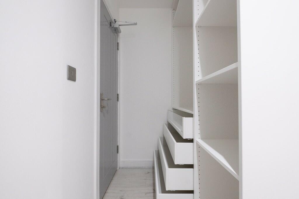 Bright, modern hallway with built-in shelving a...