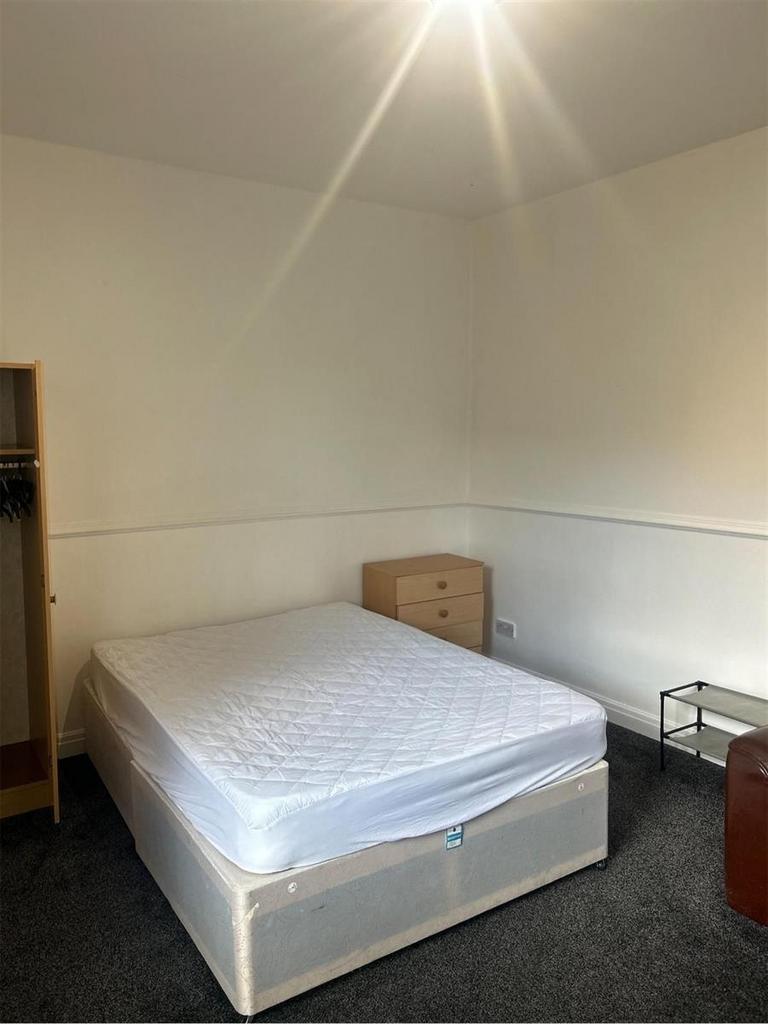 A comfortable double bedroom featuring a large ...