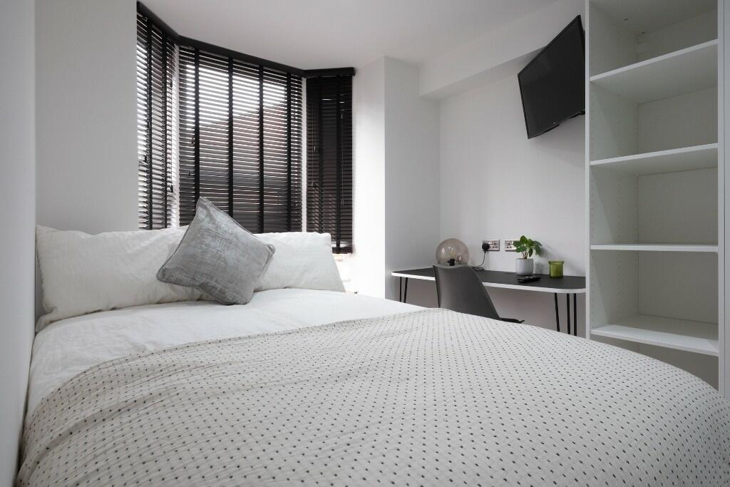 Bright and spacious master bedroom with large w...