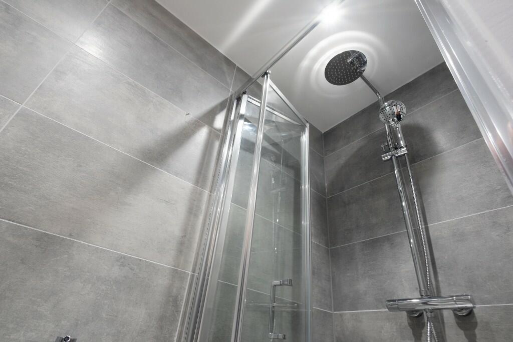 A modern, clean bathroom featuring a large show...