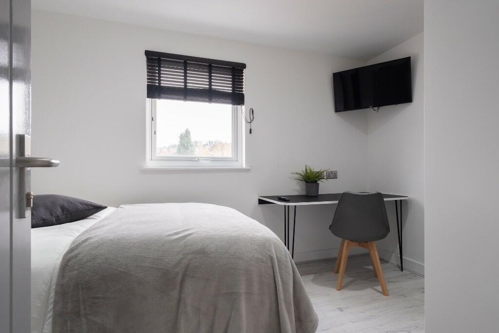 A modern, tidy bedroom featuring a comfortable ...