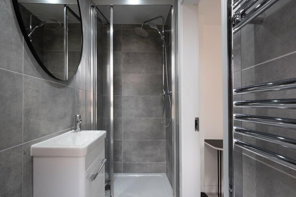 Modern and clean bathroom suite featuring a lar...