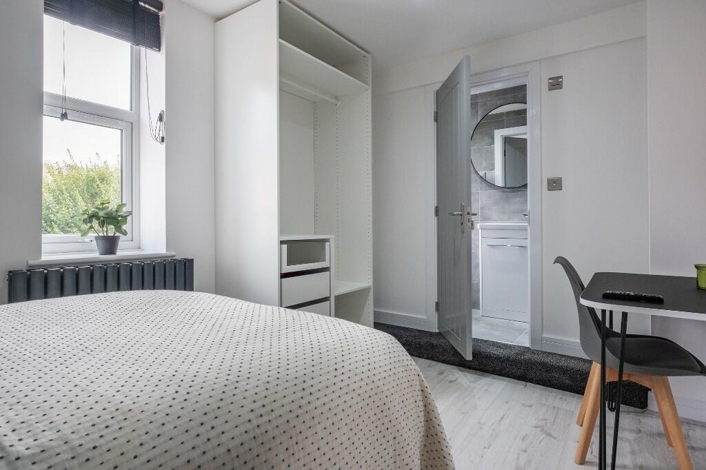 A bright and inviting bedroom featuring a large...