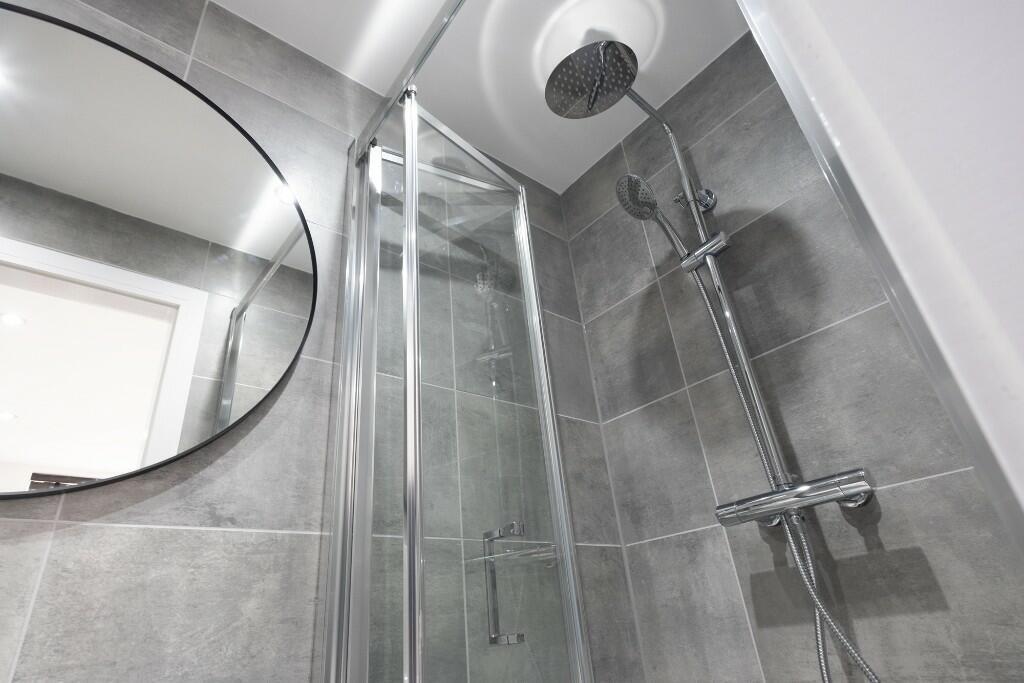 A clean, modern bathroom featuring a spacious s...