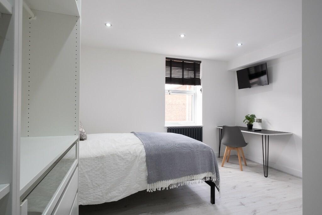 A bright and neatly presented bedroom featuring...