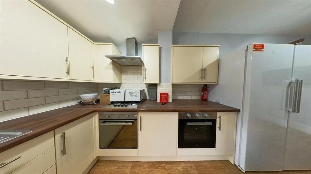Bright modern kitchen with white cabinets, wood...